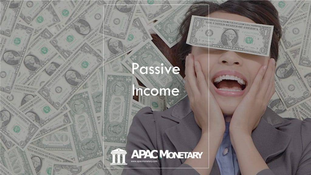 Asian lady smiling while lying on bed of money and day dreaming about what passive income is all about